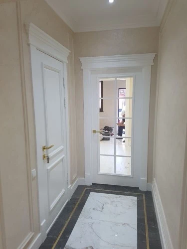 Фото двух белых установленных межкомнатных дверей в квартире, одно из них в полном остекленении