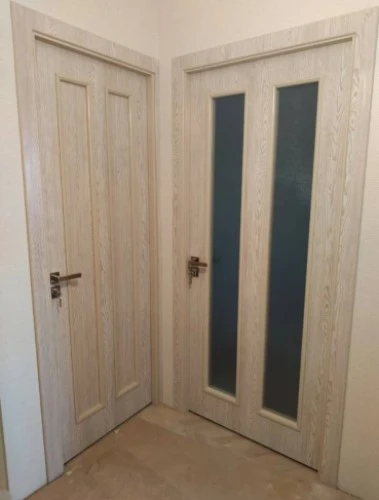 Фото двух бежевых установленных межкомнатных дверей в квартире, одно из них в полном остекленении